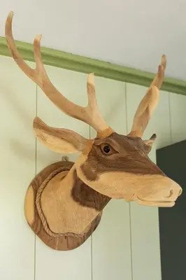 a wooden trophy of a deer head hanging on a wall at Cottage 'Onder de boompjes' in Oostwoud