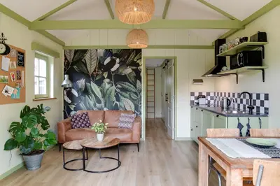 a living room with a couch and a table at Cottage 'Onder de boompjes' in Oostwoud