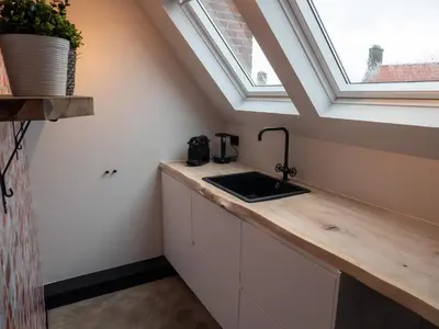 a kitchen with a sink and a window at De Boulevard 2 in Zandvoort
