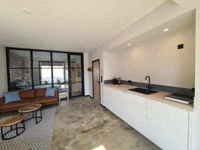 a kitchen and living room with a couch and a sink at De Boulevard 2 in Zandvoort