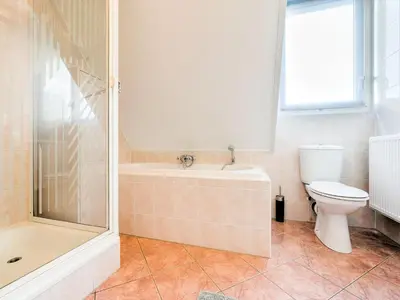 a bathroom with a tub and a toilet and a shower at Holiday Home in Zeewolde near Forest in Zeewolde