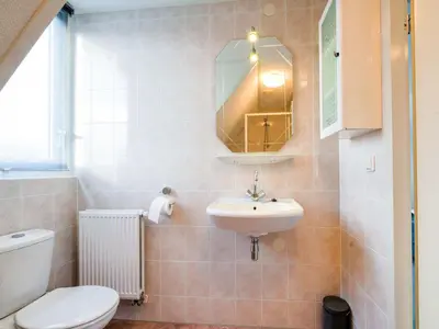 a bathroom with a toilet and a sink at Holiday Home in Zeewolde near Forest in Zeewolde