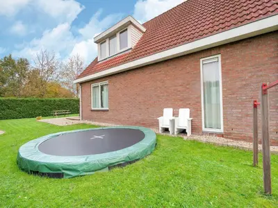 a trampoline in the yard of a house at Holiday Home in Zeewolde near Forest in Zeewolde