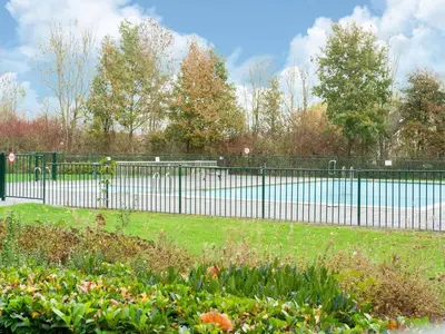 a black fence in a park with a body of water at Holiday Home in Zeewolde near Forest in Zeewolde