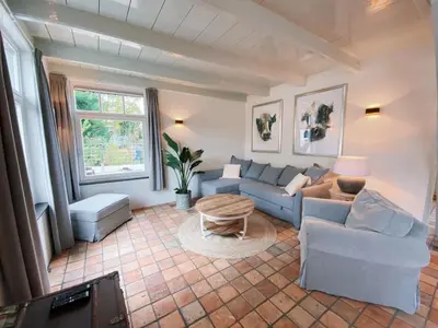 a living room with a couch and a table at Cozy historical Cottage (Huisje HèHè) in Wassenaar