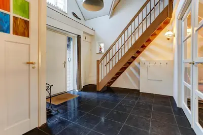 a hallway with a staircase and a tile floor at Villa Leeuwerik (4-12 p.) in Zeewolde