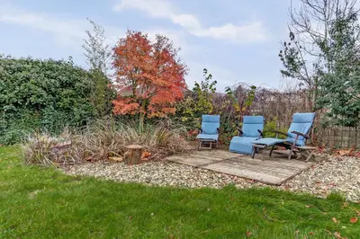 two chairs and a table in a garden at Villa Leeuwerik (4-12 p.) in Zeewolde