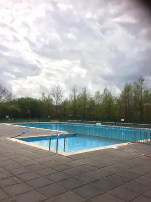 a large swimming pool on a cloudy day at Villa Leeuwerik (4-12 p.) in Zeewolde