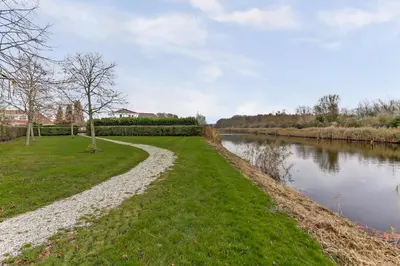 a path next to a river next to a grass field at Villa Leeuwerik (4-12 p.) in Zeewolde