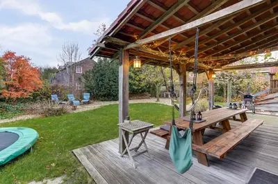 a wooden deck with a picnic table and a gazebo at Villa Leeuwerik (4-12 p.) in Zeewolde