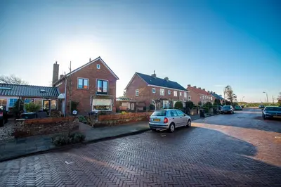 a car parked in a parking lot next to houses at De Lijsterhof in Zandvoort