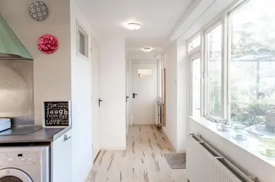 a kitchen with white walls and a window at De Lijsterhof in Zandvoort