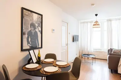 a living room with a dining room table with chairs at Canal View Apartment in Amsterdam
