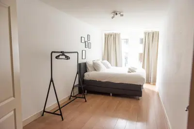a bedroom with a bed and a tripod next to a window at Canal View Apartment in Amsterdam