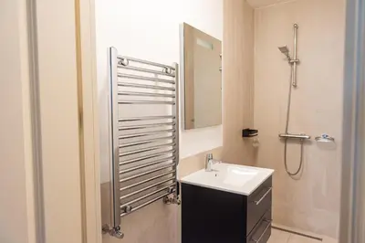 a bathroom with a sink and a shower with a mirror at Canal View Apartment in Amsterdam