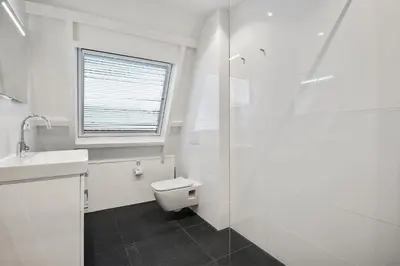 a white bathroom with a toilet and a sink at Five Churches View apartments in Haarlem