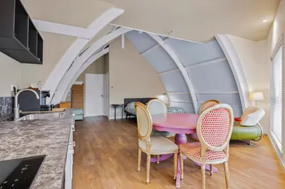 a dining room with a pink table and chairs at Five Churches View apartments in Haarlem