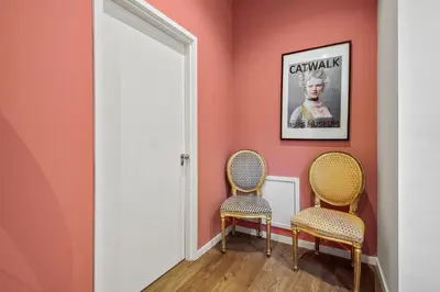 two chairs in a hallway with pink walls at Five Churches View apartments in Haarlem