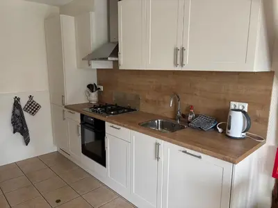 a kitchen with white cabinets and a sink at Christinahoeve Logies Oude Deel in Boskoop