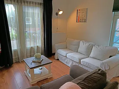 a living room with a couch and a table at Christinahoeve Hooiberg #5 in Boskoop