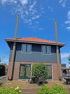 a house with two chimneys on top of it at Christinahoeve Hooiberg #5 in Boskoop