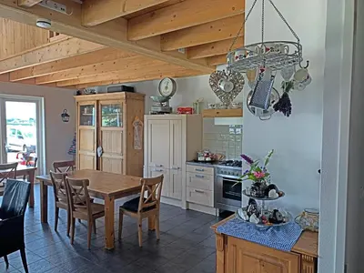 a kitchen with a wooden table and a dining room at Christinahoeve Logies in Boskoop