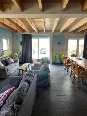 a living room with couches and a table and chairs at Christinahoeve Logies in Boskoop