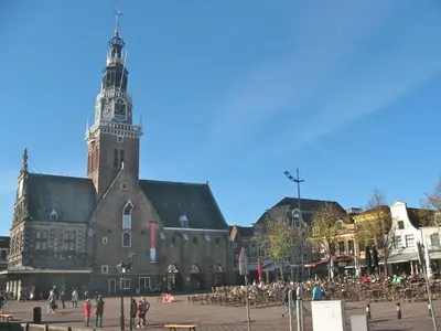 a large building with a clock tower in a city at Lovely Bungalow 8p close to beach and Amsterdam in Opmeer
