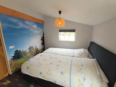 a bedroom with a bed with a painting on the wall at Mariahoeve-Logies #'t Hooihuis in Woubrugge