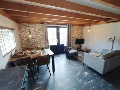 a living room with a table and a couch at Mariahoeve-Logies #'t Hooihuis in Woubrugge