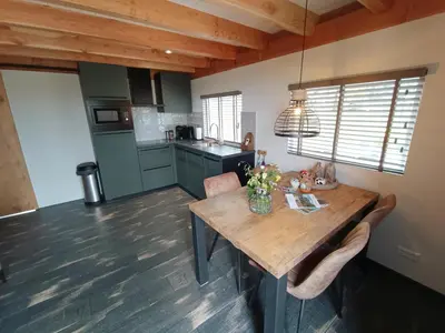 a kitchen with a wooden table in a room at Mariahoeve-Logies #'t Hooihuis in Woubrugge