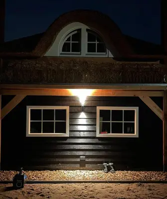 a light on the side of a house at night at Mariahoeve-Logies #'t Hooihuis in Woubrugge