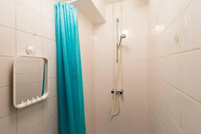a bathroom with a shower with a blue shower curtain at Charming apartment in city center in Amsterdam