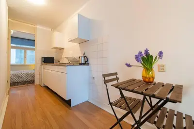 a kitchen with a wooden table and a vase of flowers at Charming apartment in city center in Amsterdam
