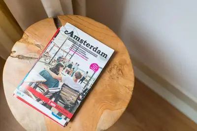 a magazine sitting on top of a wooden table at Charming apartment in city center in Amsterdam