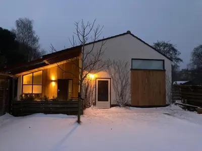 a small house in the snow with a door at Luxe vakantiehuis met sauna De Barn Bergen in Bergen