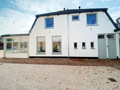 a white house with a lot of windows at Luxurious historical Loft close to the beach!! in Wassenaar