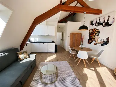 a living room with a couch and a table at Luxurious historical Loft close to the beach!! in Wassenaar