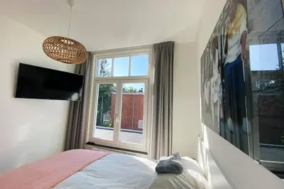 a bedroom with a bed and a window at Luxurious historical Loft close to the beach!! in Wassenaar