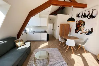 a living room with a couch and a table at Luxurious historical Loft close to the beach!! in Wassenaar