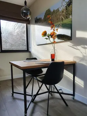 a desk with a chair and a vase with flowers at @TheLodge in Haarzuilens