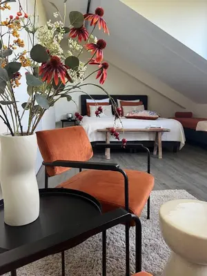 a bedroom with a bed and a table with flowers at @TheLodge in Haarzuilens