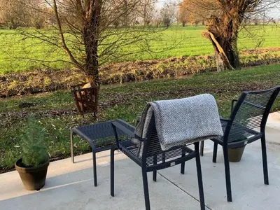 two chairs and a table with a sweater on them at @TheLodge in Haarzuilens