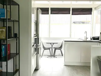 a kitchen with a table and chairs in a room at Alibi aan Zee in Wijk aan Zee