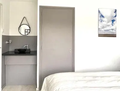 a bedroom with a door leading to a bed and a sink at Alibi aan Zee in Wijk aan Zee