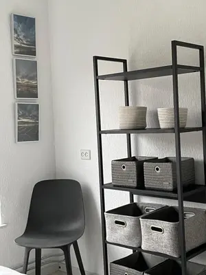 a room with a chair and a shelf with baskets at Alibi aan Zee in Wijk aan Zee