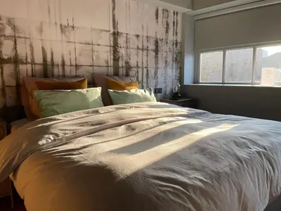a large bed in a bedroom with a window at Daen’s Greenhouse in Utrecht