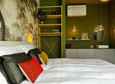 a bedroom with green walls and a bed with red pillows at Daen’s Greenhouse in Utrecht