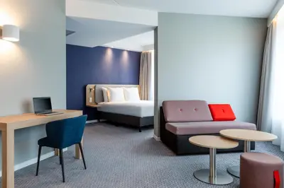 a hotel room with a couch and a bed at Holiday Inn Express - Almere by IHG in Almere