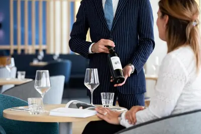 a man holding a bottle of wine next to a woman at Holiday Inn Express - Almere by IHG in Almere